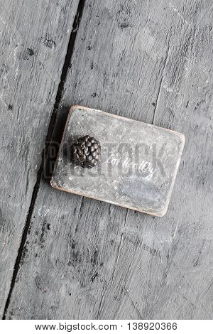 Eat heathy inscription and blackberries on a wooden table.