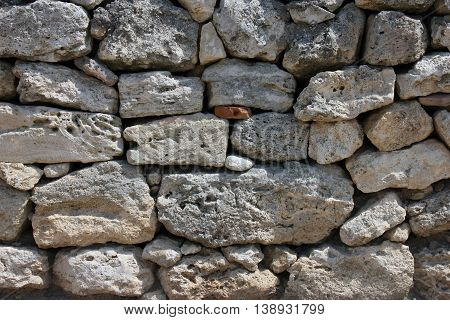 texture of old dilapidated shabby sandstone masonry of wild natural sandstone stones wall foreground closeup in Crimea
