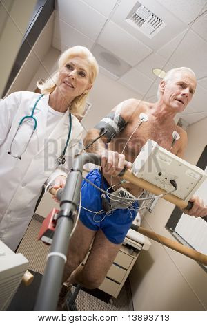 Doctor Monitoring The Heart-Rate Of Patient On A Treadmill