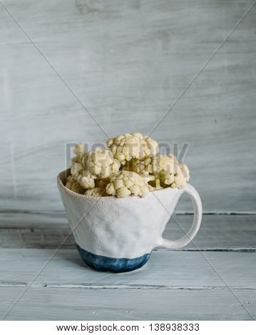 cup of clay with cauliflower cauliflower in a ceramic cup cauliflower on a light background.