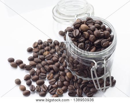 heap of coffee beans isolated on a white background from glass jar