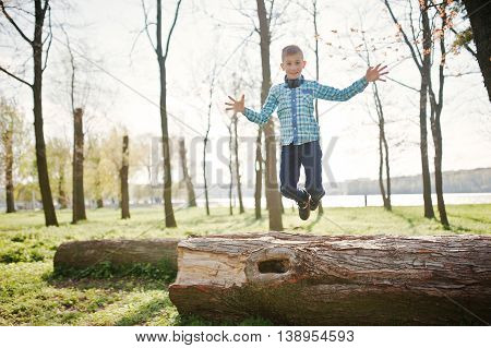 Little Fun Boy Jump Froom Tree Stump At Park