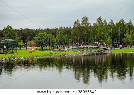 RUSSIA, BELGOROD - June 13 2016: New Belgorod zoo in the woods. Walkup and the bridge across the pond.