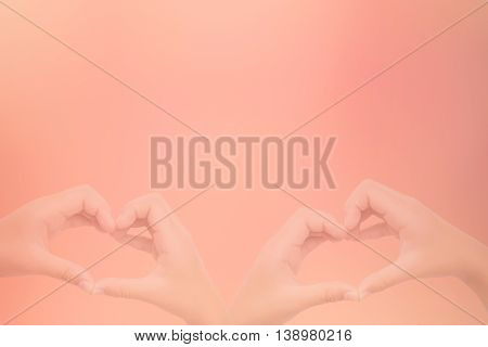 kid hands making a heart shape with sweet background