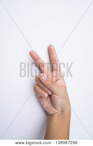 child hand shows the number two on white background