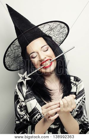 Funny Witch. Young happy woman with canival hat. Studio shot.