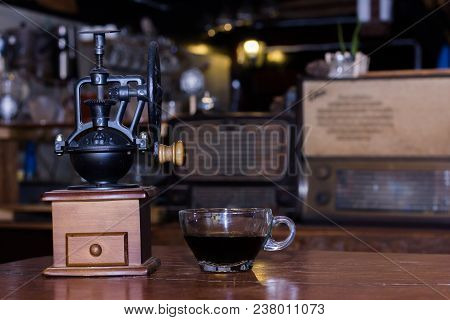 Coffee Grinders And Black Coffee Cups Are On The Table.