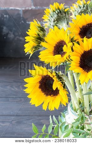 Bouquet Of Bright Sunflowers In A Glass Jar On A Wooden Table.