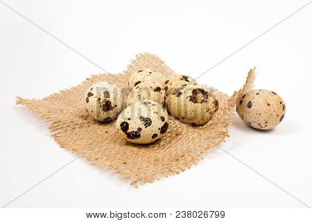 Seven Quail Eggs On Rustic Burlap Background. Spring Background With Small Easter Quail Eggs