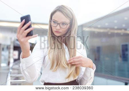 Young Blonde Businesswoman Taking Selfie In Business Center, Indoors