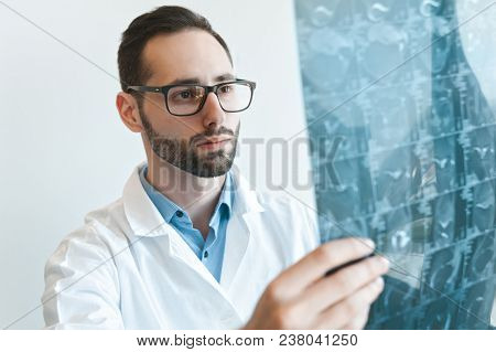 Young Doctor Looking At Magnetic Resonance Imaging Shot Of Knee-joint. Meniscus Injury