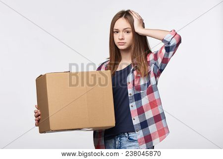 Delivery, Relocation And Unpacking Problems. Discontent Young Woman Holding Cardboard Box With Hand 