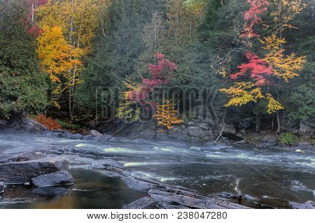An Algonquin River Rapids With Colorful Foliage In Fall