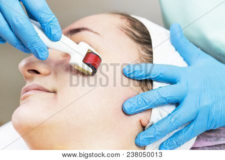 The Woman Undergoes The Procedure Of Medical Micro Needle Therapy With A Modern Medical Instrument D
