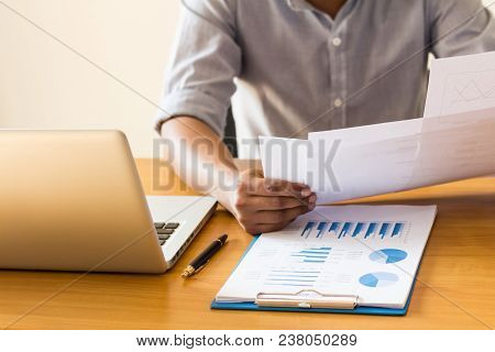 Businessmen Sit And Analyze Graphs In The Office.