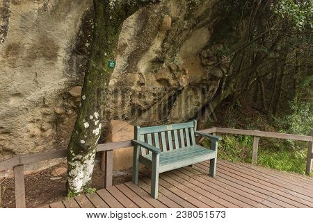 Royal Natal National Park, South Africa - March 14, 2018: A Bench And Stone Tablet Under An Overhang