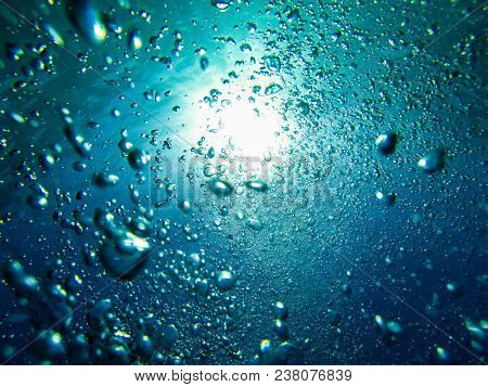 Air boobles in blue sea water. Maldives.