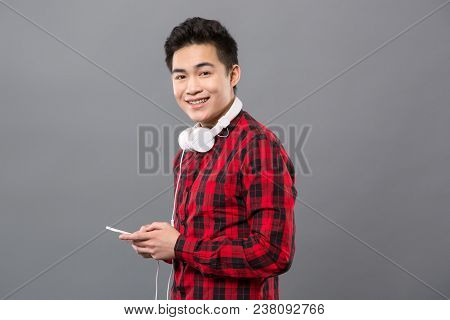 Modern Igen. Joyful Cheerful Man Smiling To You While Holding His Smartphone In The Hands