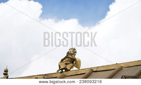 Brass Statue On The Roof With Sky