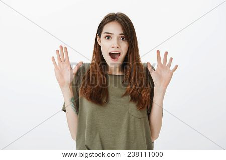 Girl Overwhelmed With Positive Emotions, Raising Hands Seeing Unbelievable Things. Studio Shot Of Sa