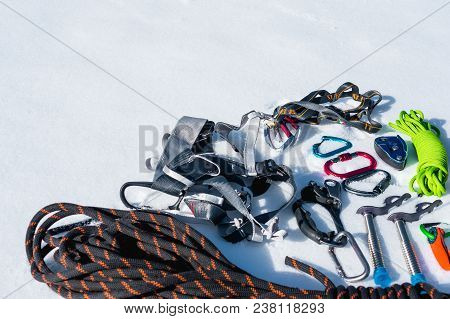Close-up Of Winter Climbing Equipment On Fresh Snow On A Sunny Day. Carbines With A Rope Gazebo And 