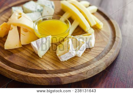 Cheese Plate. Assortment Of Various Types Of Cheese On Wooden Cutting Board.