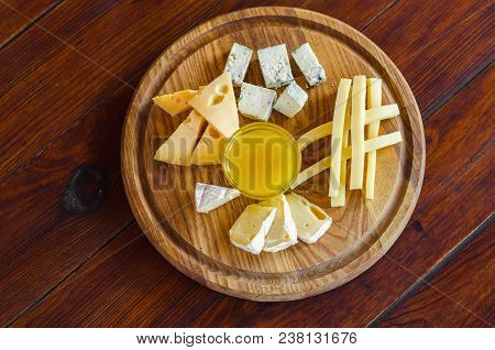Cheese Plate. Assortment Of Various Types Of Cheese On Wooden Cutting Board.