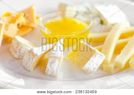 Cheese Plate. Assortment Of Various Types Of Cheese On Wooden Cutting Board.