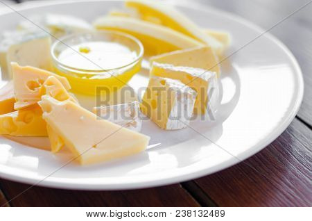 Cheese Plate. Assortment Of Various Types Of Cheese On Wooden Cutting Board.