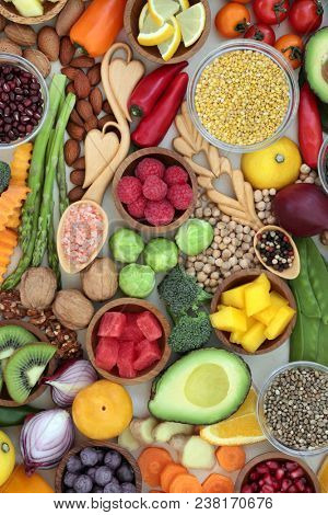 Healthy food for well being  with fruit, vegetables, herbs, pulses, grains, nuts, seeds with peppercorns & himalayan salt in love spoons. High in antioxidants, vitamins, minerals & anthocynins. 