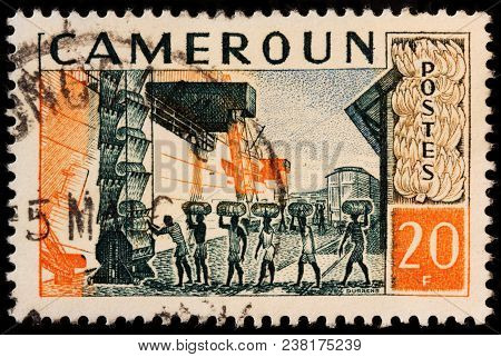 Luga, Russia - October 7, 2017: A Stamp Printed By Cameroon Shows Loading Of The Vessel Carrying Cam