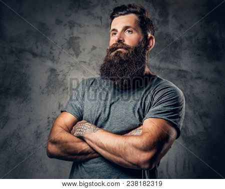 Brutal Bearded Male With Tattoos On Arms Over Grey Background.