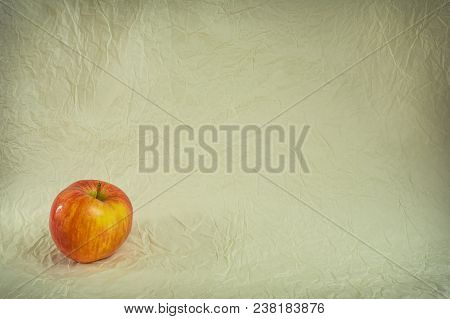 Apple In The Lower Left Corner On Crumpled Paper