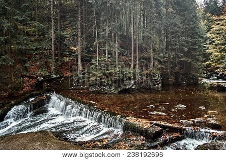 Waterfall In Nature Pine Scandinavian Mountain Forest In Evening Light. Wet Cold Rock Stones Covered