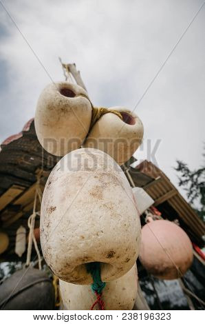 Close Up And Lower Angle Image Group Of Dirty White Fish Net Buoy Tied With Rope, Hanging Under Wood