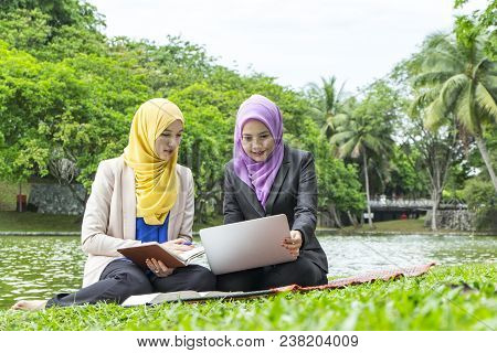 Portrait Of Young Lovely Pleasant Mix Ethnic Woman Sitting On Grass At Summer Green Park And Having 