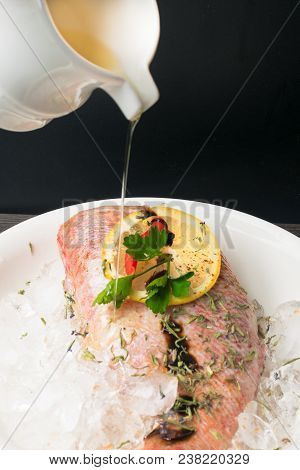 Whole Raw Organic Fish Sea Perch On Ice Cubes With Lemon, Sy Sauce, Greens, Red Pepper, In White Pla