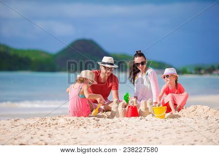 Family Making Sand Castle At Tropical Beach. Family Spend Time Together On Summer Vacation