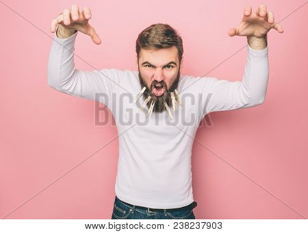 Man Is Screaming And Yeling. He Is Trying To To Be Fearless And To Threat Everyone. Isolated On Pink