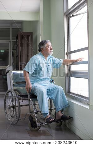 Asian Old Man Sit On Wheelchair Looking Out To Other Place. People With Health Care And Medical Conc