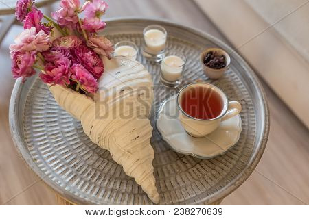 Pink Ranunculus In Seashell Shaped Vase And Carcade Tea In A Cup