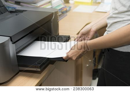 Woman Inserting Paper Sheet On A Printer Tray Waiting To Feed For Printing A Job By Hand