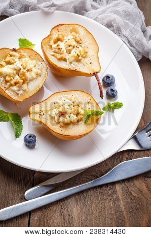 Pears Baked With Ricotta Cheese, Nuts, Honey And Cinnamon On Rustic Wooden Background