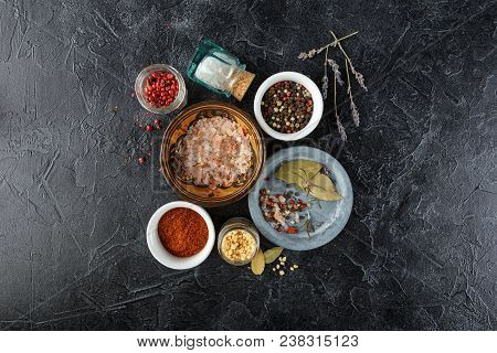 Pink, Gold And White Salt, Black And Red Peppercorns, Bay Leaf, Paprika On A Black Background Top Vi