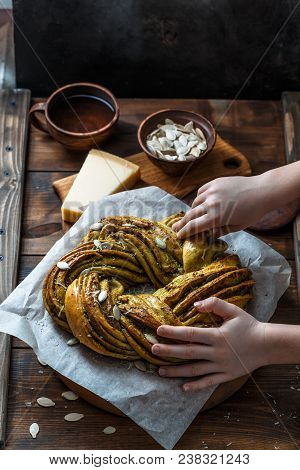 Babka Brioche Wreath With Pesto And Parmesan With Hands.