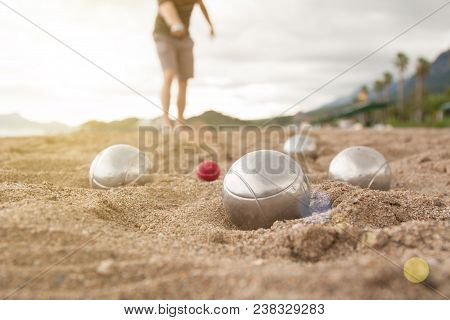 Beach. A Game Of Bocha. Brilliant Silver Balls For A Bocha On The Sand.