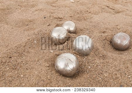 Beach. A Game Of Bocha. Brilliant Silver Balls For A Bocha On The Sand.