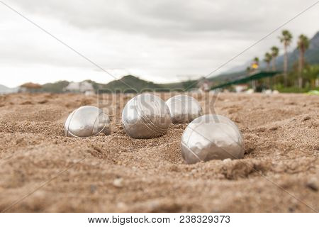 Beach. A Game Of Bocha. Brilliant Silver Balls For A Bocha On The Sand.