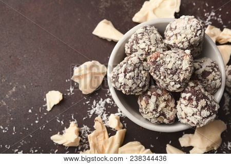 White Crushed Chocolate Pieces On Dark Background And Truffles In Waffle Crus, Closeup, Copy Space. 