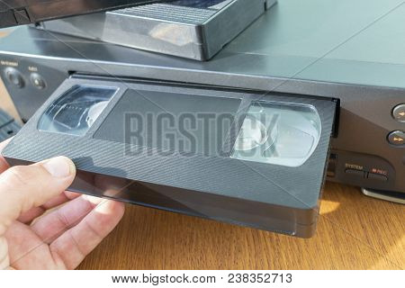 Videocassette Is Put Into The Video Recorder To Watch The Video, Another Video Cassette Is On The Vi